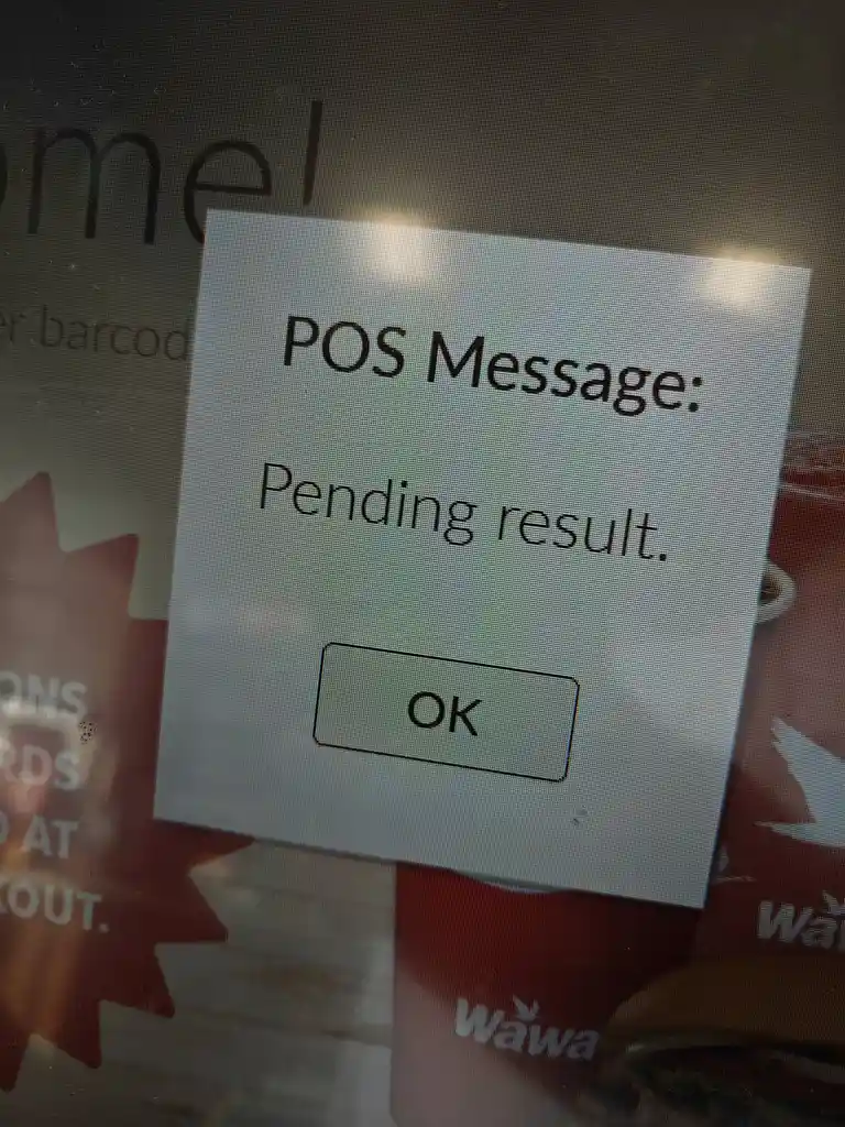 A close-up photo of a point-of-sale (POS) terminal screen showing a pop-up message that reads 'POS Message: Pending result.'…
