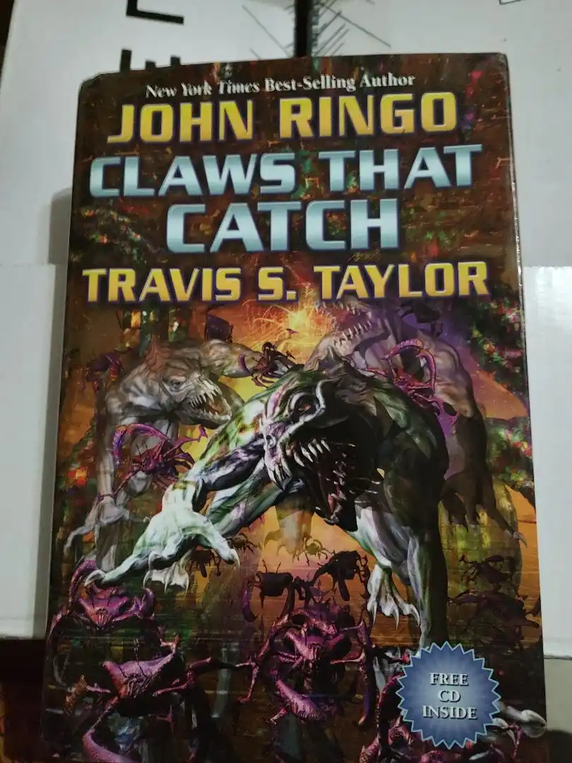 A book cover for 'Claws That Catch' by John Ringo and Travis S. Taylor, featuring a violent illustration of monstrous…