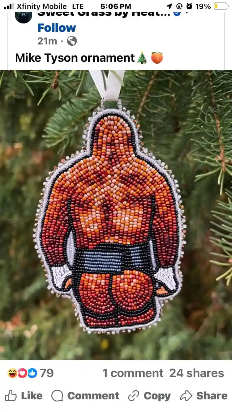 A beaded Christmas ornament shaped like Mike Tyson, depicted from the back wearing boxing shorts and gloves, hanging on a…