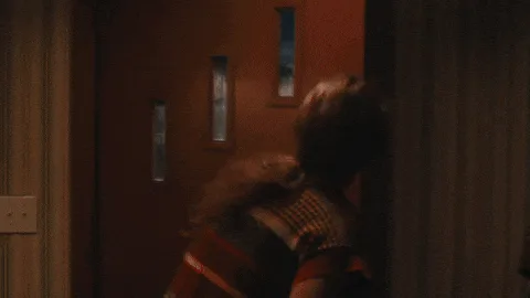 A composite image from Taylor Swift's 'Anti-Hero' music video, showing her in different outfits and poses at a doorway at…