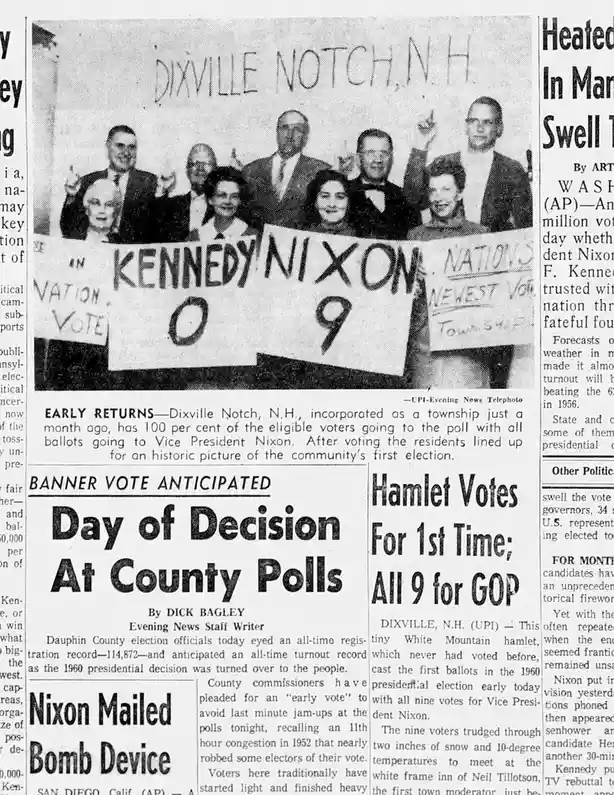 A black-and-white newspaper clipping shows nine people holding signs in Dixville Notch, N.H., with one large sign reading…