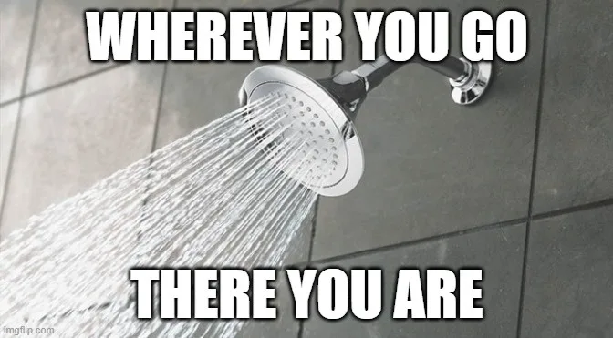 A close-up photo of a showerhead spraying water against a tiled wall, with bold white text overlaid at the top and bottom…