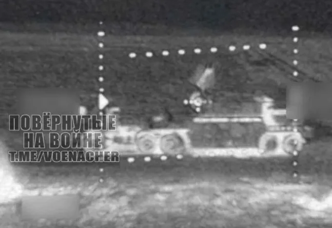 A grainy, black-and-white night-vision image shows a military tank with its turret turned to the side, framed by a dotted…