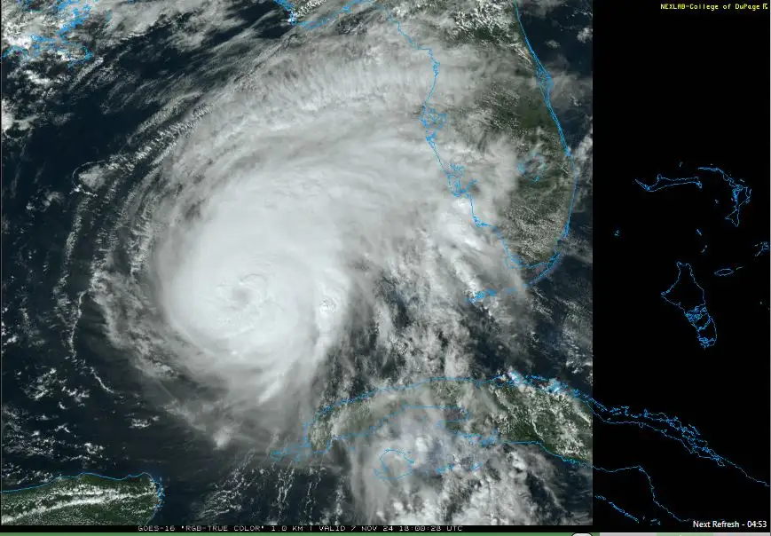 A satellite image shows a massive hurricane with a distinct eye, swirling over the Atlantic Ocean near the southeastern…