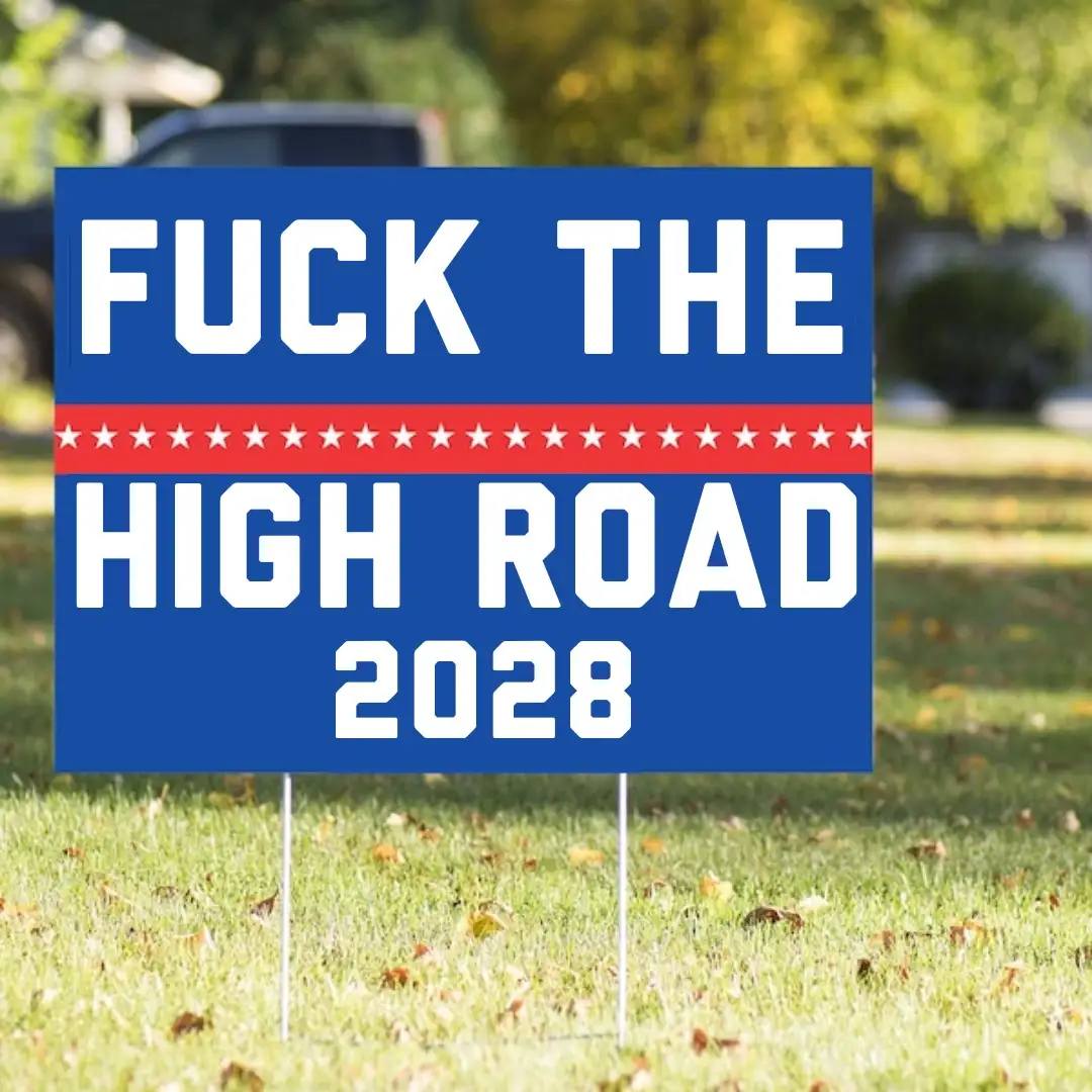 A blue political yard sign with white text reading 'FUCK THE HIGH ROAD 2028' and a red stripe with white stars in the…
