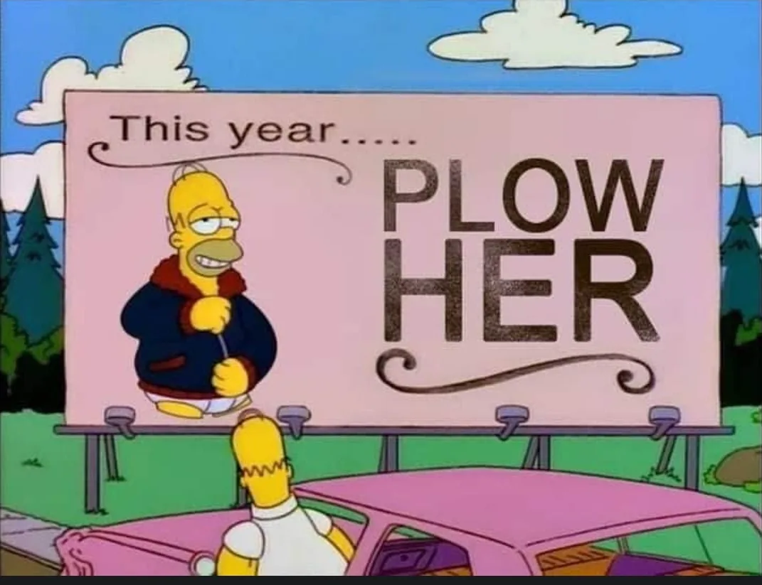A cartoon image shows Homer Simpson in a pink car looking up at a large pink billboard. The billboard features a picture of…