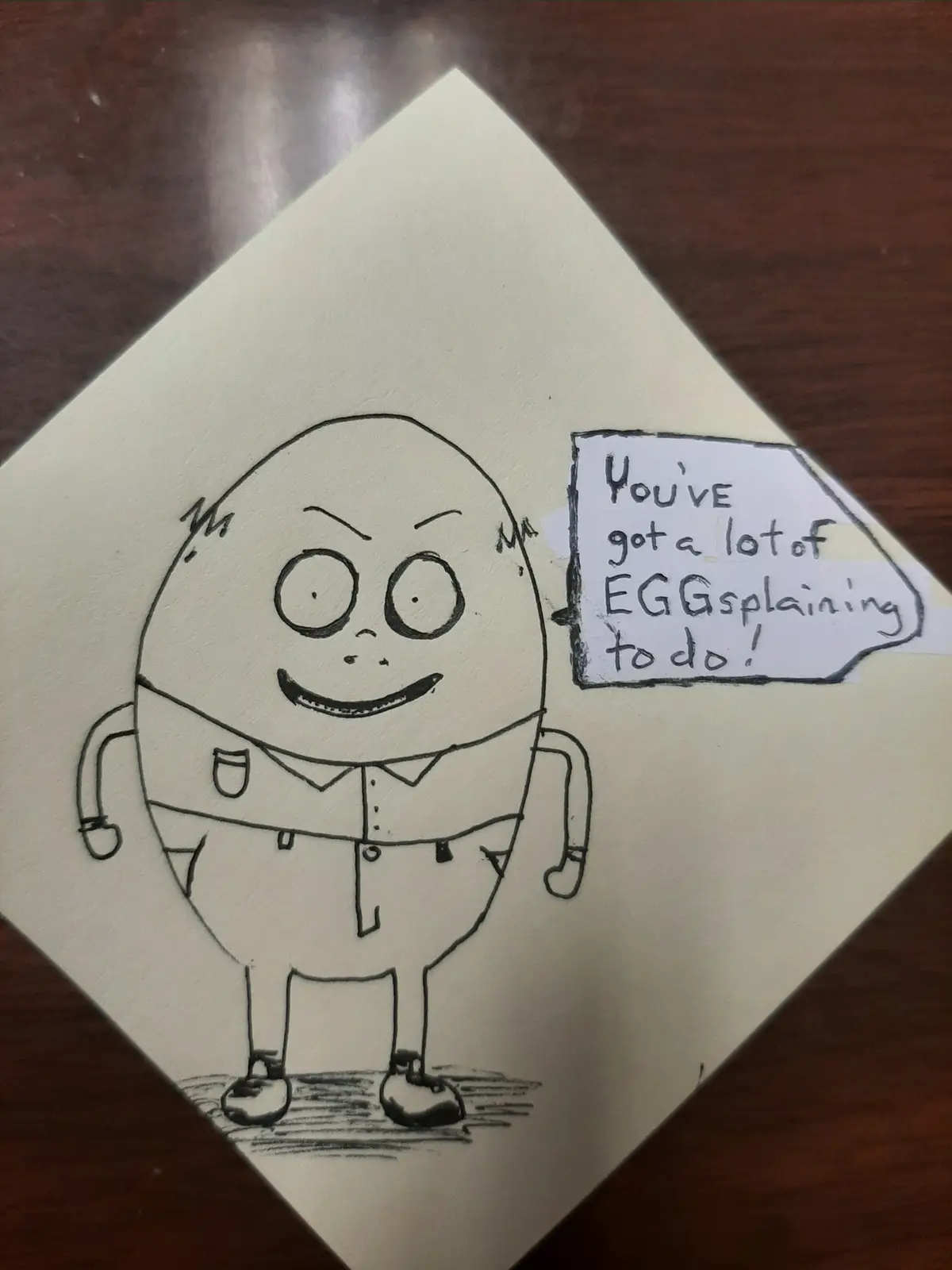 A hand-drawn cartoon of an egg-shaped character wearing a collared shirt and pants, standing on a sticky note. The character…