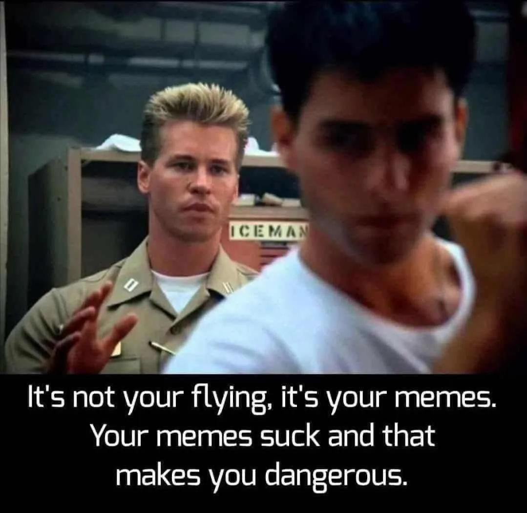 A still from the movie 'Top Gun' shows two men in a hangar. The man in the foreground, wearing a white t-shirt, is blurred…