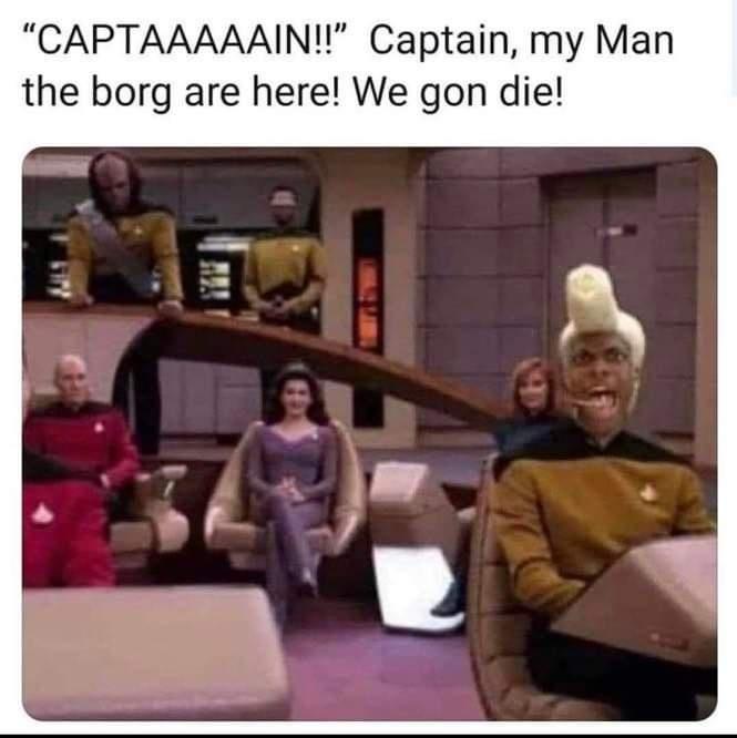 A still from Star Trek: The Next Generation shows the crew in the bridge, with the captain in red seated, a woman in purple…