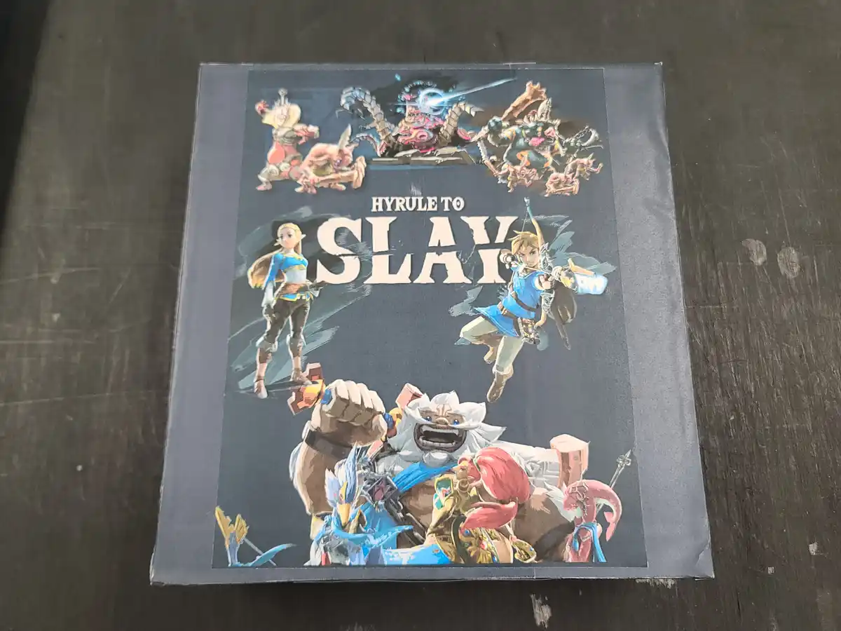 A physical book or box cover featuring artwork from The Legend of Zelda series, showing characters like Link and Zelda…