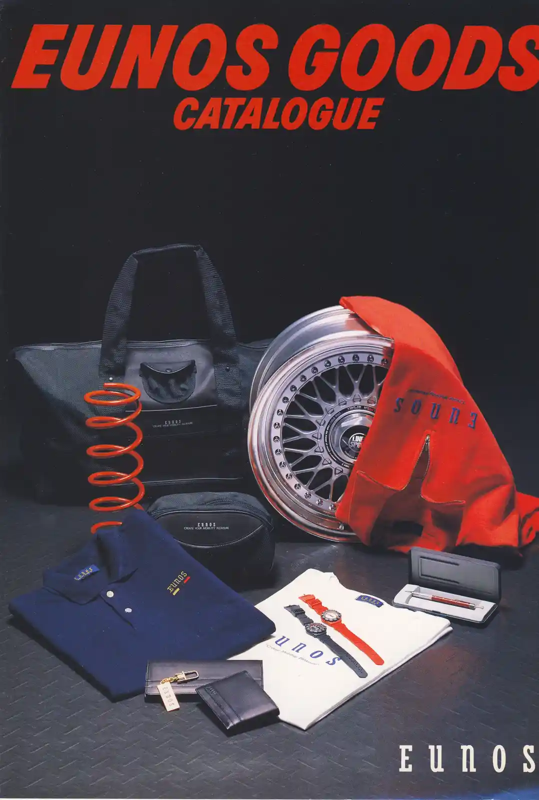 The image displays a vintage Eunos Goods catalogue cover featuring a collection of branded merchandise including a black…