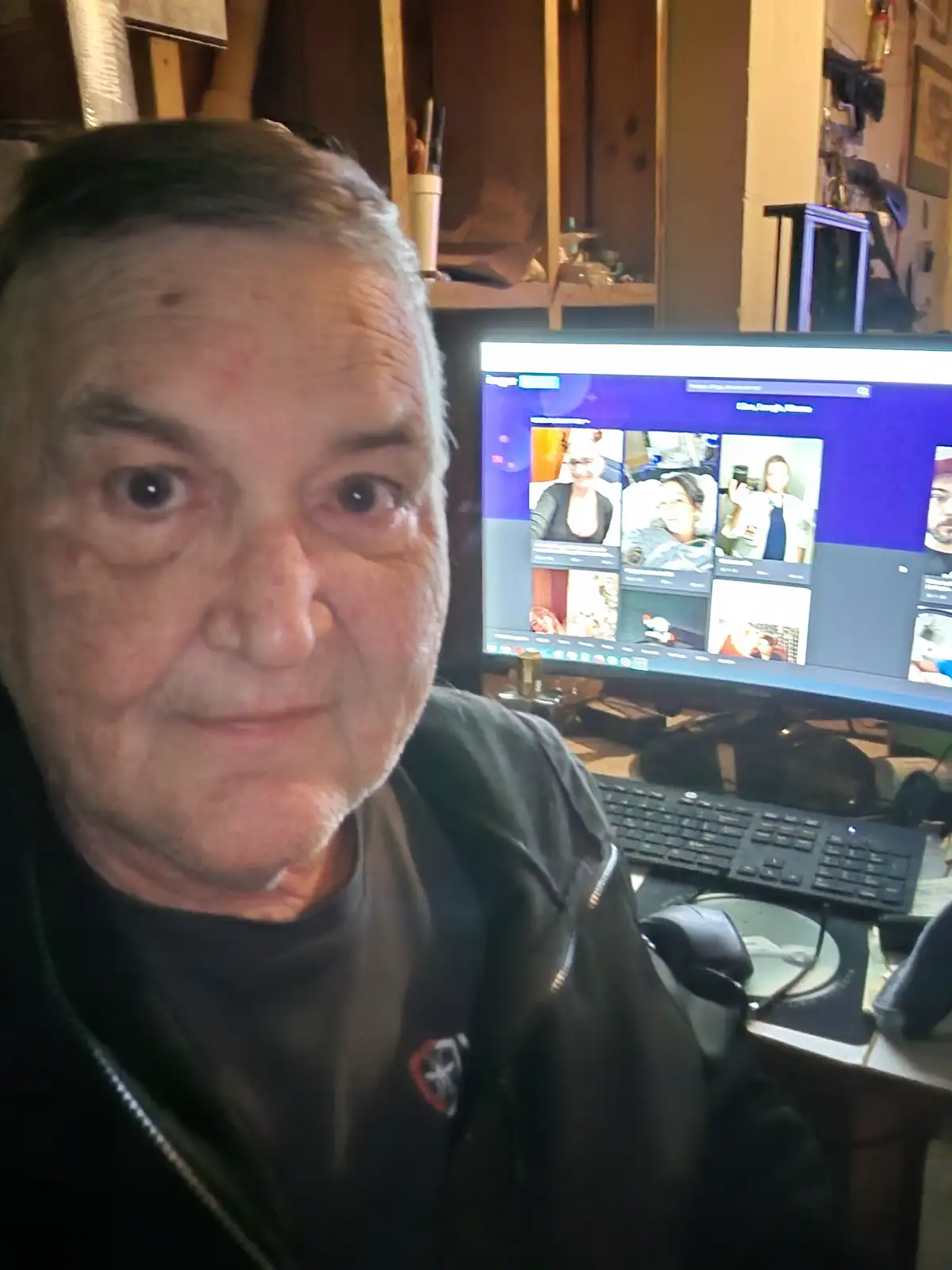 A close-up photo of an older man with a slightly annoyed or unimpressed expression, looking directly at the camera. Behind…