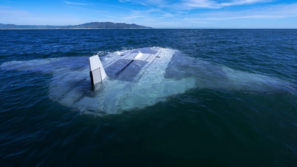 A white, sleek, modern-looking object, resembling a futuristic submarine or underwater vehicle, is partially submerged in…