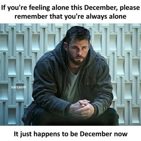 A man with a serious, somber expression sits hunched on the ground against a white geometric wall. The overlaid text reads…