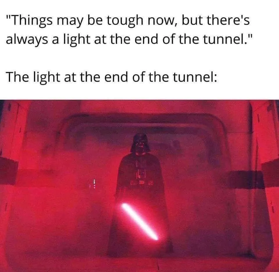 A still image of Darth Vader standing in a dim, red-lit tunnel, holding a glowing red lightsaber. The text above reads…