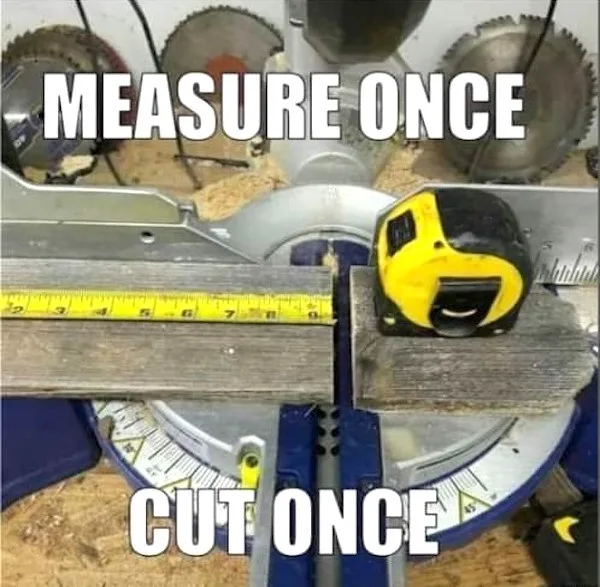 A close-up photo of a woodworking miter saw with a yellow and black tape measure resting on a wooden plank. The saw blade is…
