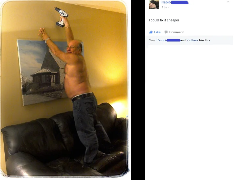 A shirtless man stands on a black leather couch, holding a power drill above his head as if installing something on the…