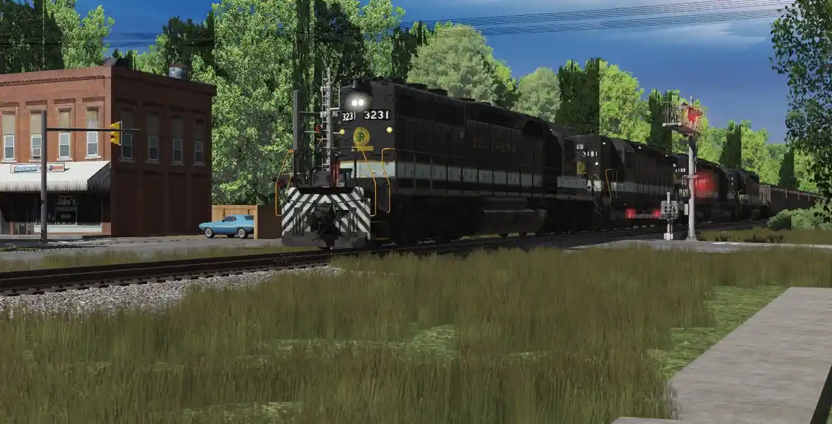 A black Southern Railway locomotive, number 3231, is shown approaching a crossing with red signals lit, passing a brick…
