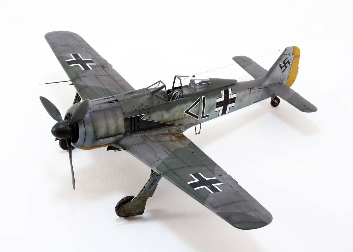 A detailed scale model of a German World War II fighter aircraft, likely a Messerschmitt Bf 109, is displayed against a…