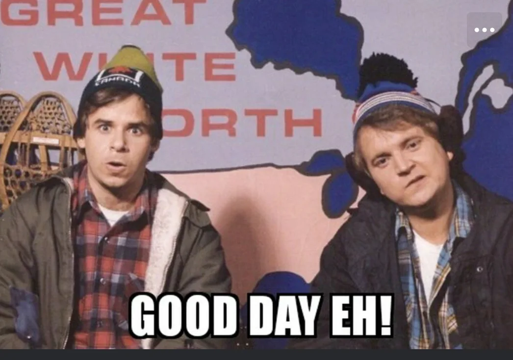 Two men in winter hats and jackets sit in front of a backdrop with 'GREAT WHITE NORTH' text and a map outline. The man on…