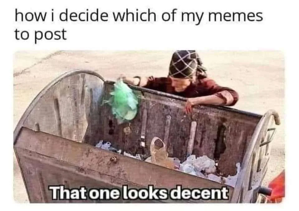 A person wearing a patterned head covering leans over the edge of a large, rusty metal dumpster filled with trash, looking…