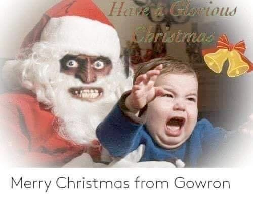 A distorted, menacing Santa Claus with darkened skin and wide eyes looms behind a crying baby who is waving one hand. The…
