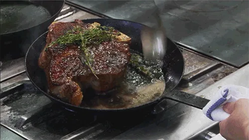 A six-panel image shows a person cooking a large, seared steak in a cast iron skillet on a stovetop. In the first three…