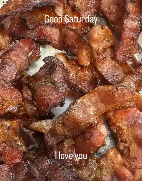 A close-up photo of crispy, golden-brown cooked bacon strips piled together on a white surface. White text overlaid on the…