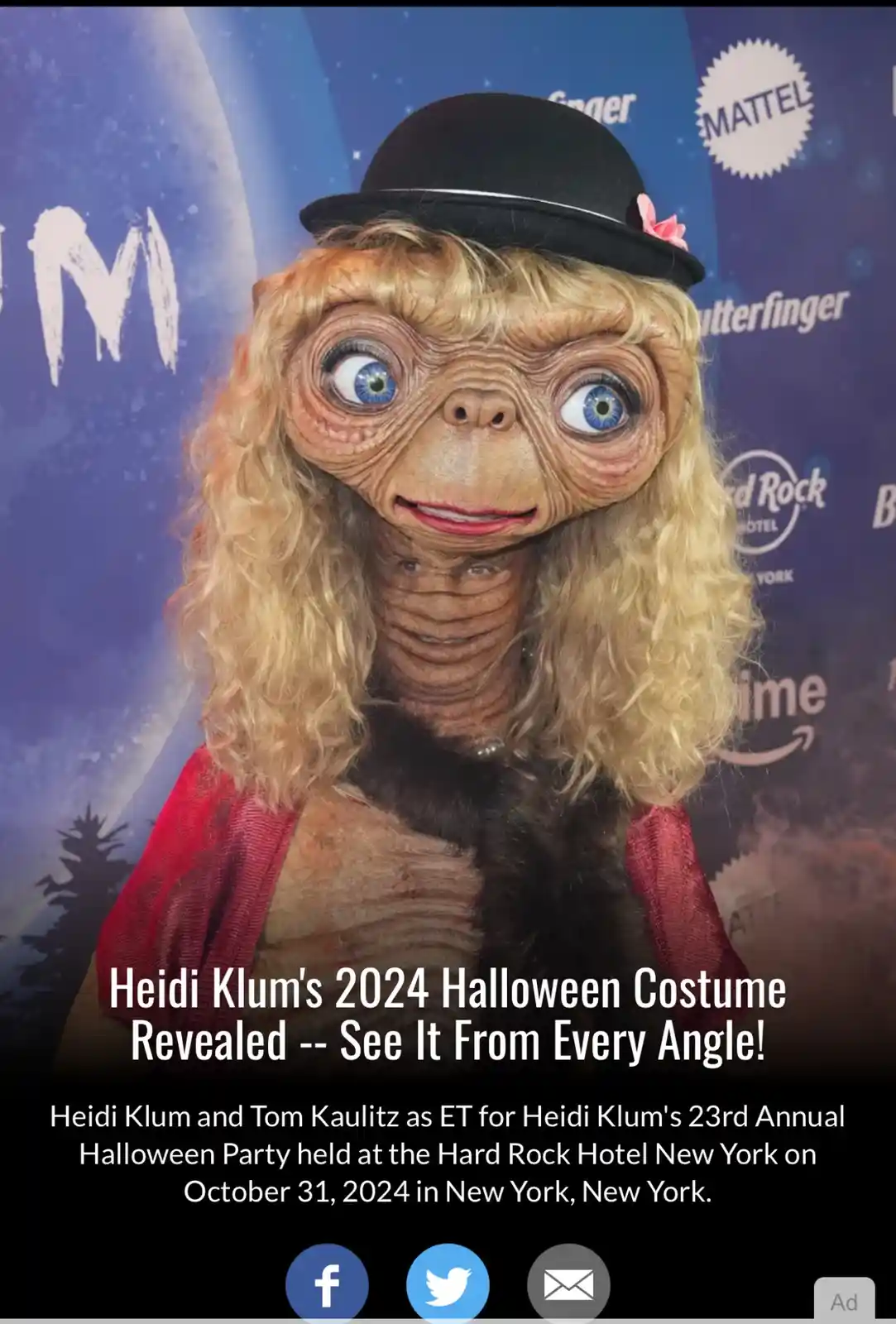 A person wearing a full-body ET costume with a blonde wig, a black bowler hat with a pink flower, and a red jacket, posing…