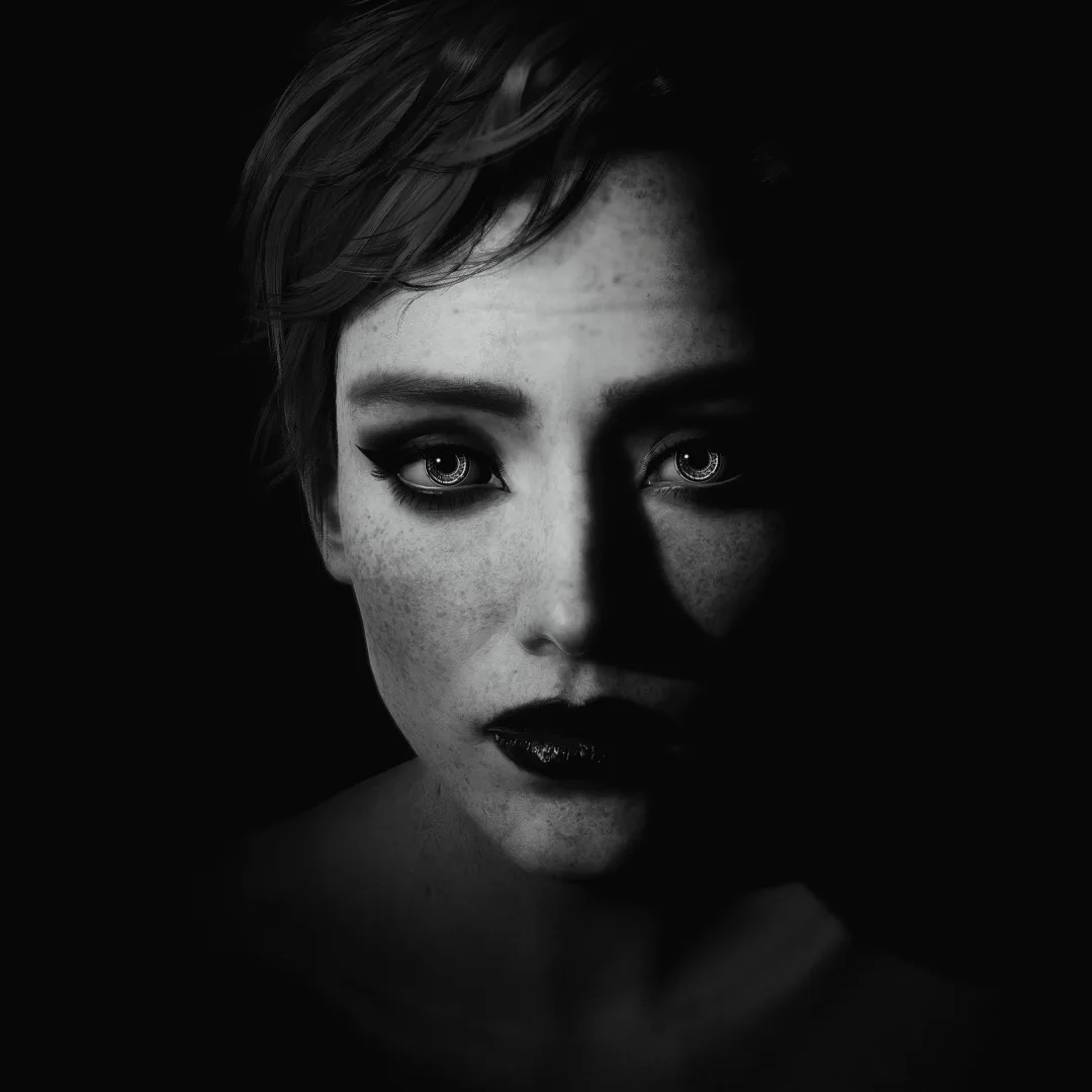 A black-and-white portrait of a woman with short hair, freckles, and dark lipstick, half her face in shadow, looking…