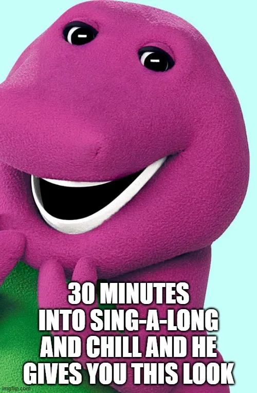 A close-up of the purple, smiling, plush dinosaur character Barney from children's television, with white teeth and a green…