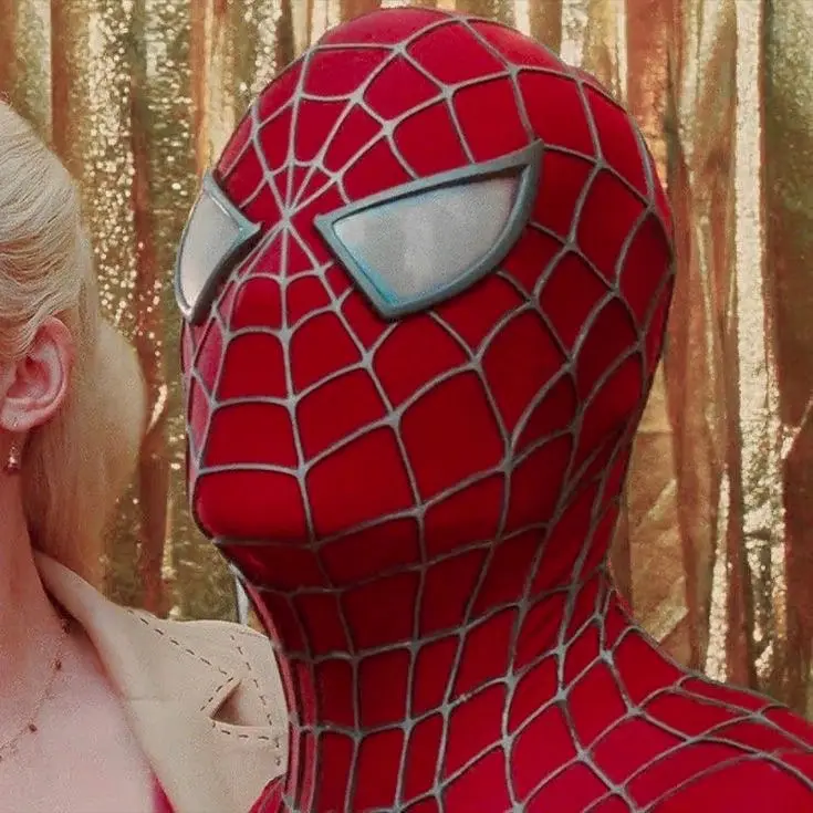 A close-up image shows Spider-Man in his classic red and blue suit, facing a blonde woman in a beige jacket. The woman is…