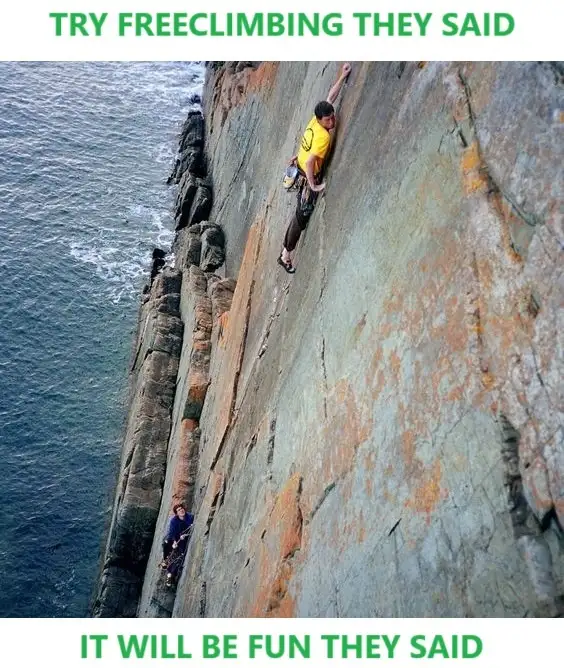 A person in a yellow shirt is free climbing a steep, rocky cliff face above the ocean, with another person visible lower…
