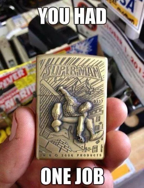 A hand holds a brass Zippo lighter engraved with Superman falling backward, with the text 'YOU HAD ONE JOB' overlaid in bold…