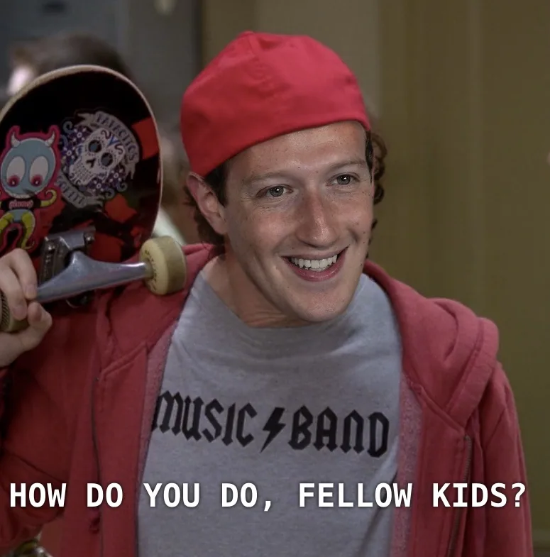 A young man with curly hair, wearing a red cap, red hoodie, and a grey t-shirt that says 'MUSIC BAND', smiles while holding…