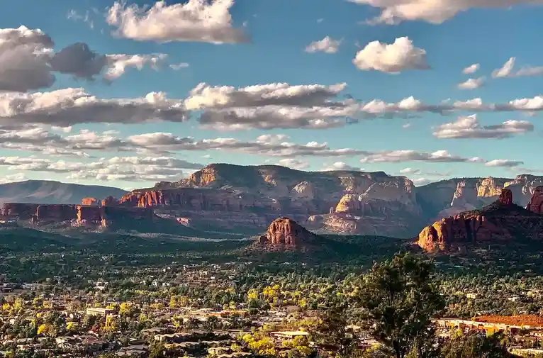 A scenic photograph of a town nestled among red rock formations under a partly cloudy blue sky, with the overlaid text 'i'm…
