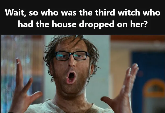 A man with messy hair and glasses has his mouth wide open in shock, hands raised in disbelief. The overlaid text reads…