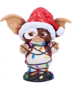 A small, brown, furry gremlin figurine wearing a red and white santa hat, is wrapped in colorful christmas lights around its…