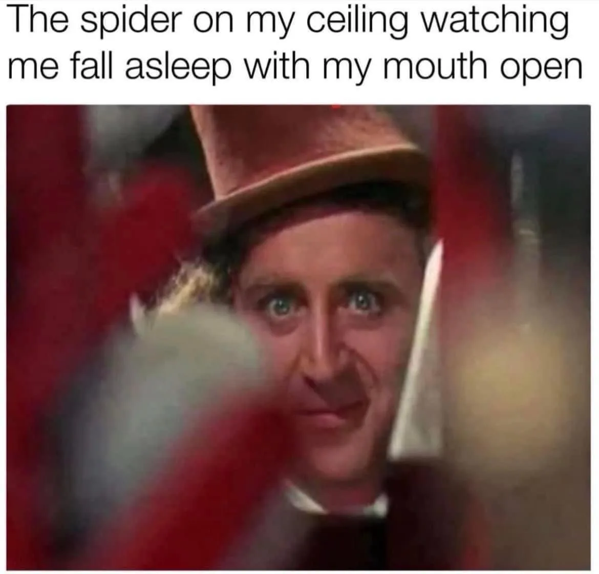 A close-up image of a man wearing a brown top hat, peering through a blurry foreground with wide, startled eyes and a slight…