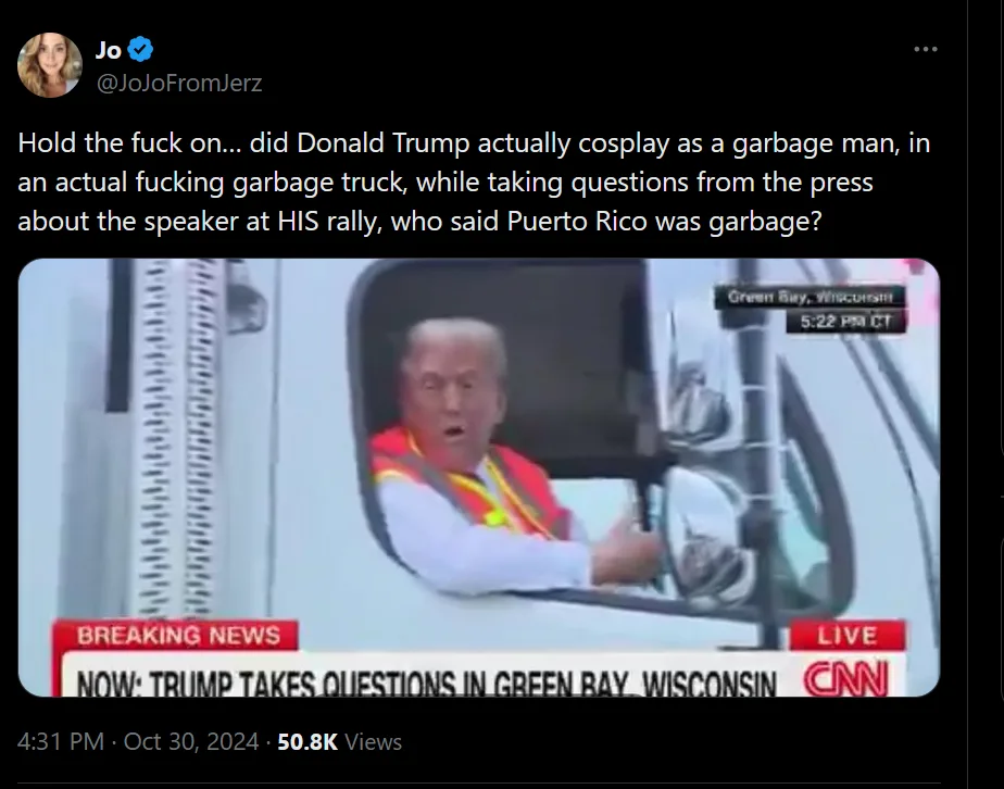A still image from a CNN broadcast shows Donald Trump sitting in the driver's seat of a white garbage truck, wearing a red…
