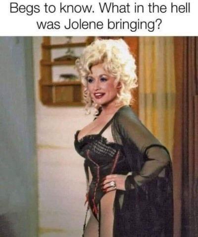 A woman with blonde curly hair, wearing a black corset and sheer black robe, poses with one hand on her hip. The overlaid…