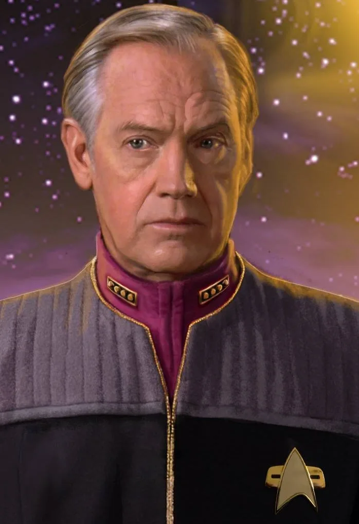 A portrait of a man in a Starfleet uniform with a stern expression, set against a starry space background. The overlaid text…
