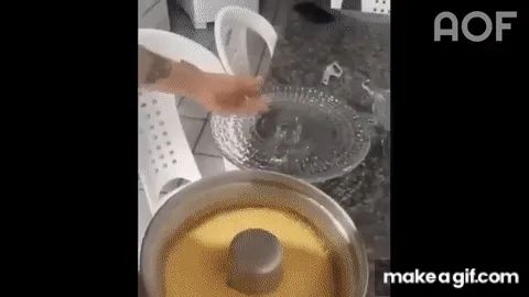A person is shown in a kitchen removing a glass lid from a metal pot containing a yellow substance, then lifting the pot to…