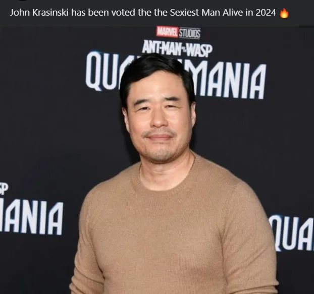 A man with dark hair and a light brown sweater stands in front of a black backdrop with 'MARVEL STUDIOS ANT-MAN-WASP…