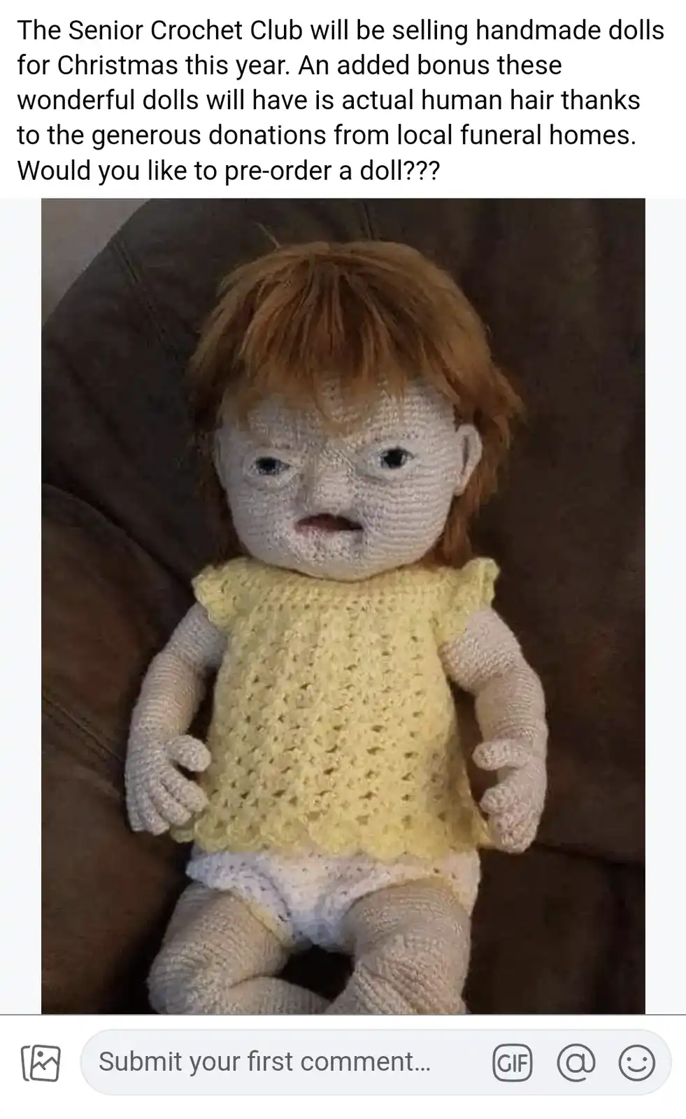 A handmade crochet doll with a pale, textured face, dark eyes, and reddish-brown yarn hair sits on a brown couch wearing a…
