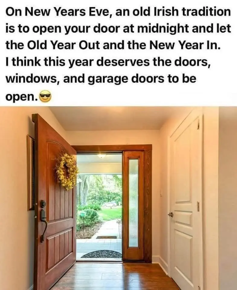 A photo shows a house interior with a wooden front door wide open, revealing a bright outdoor scene with greenery and a…